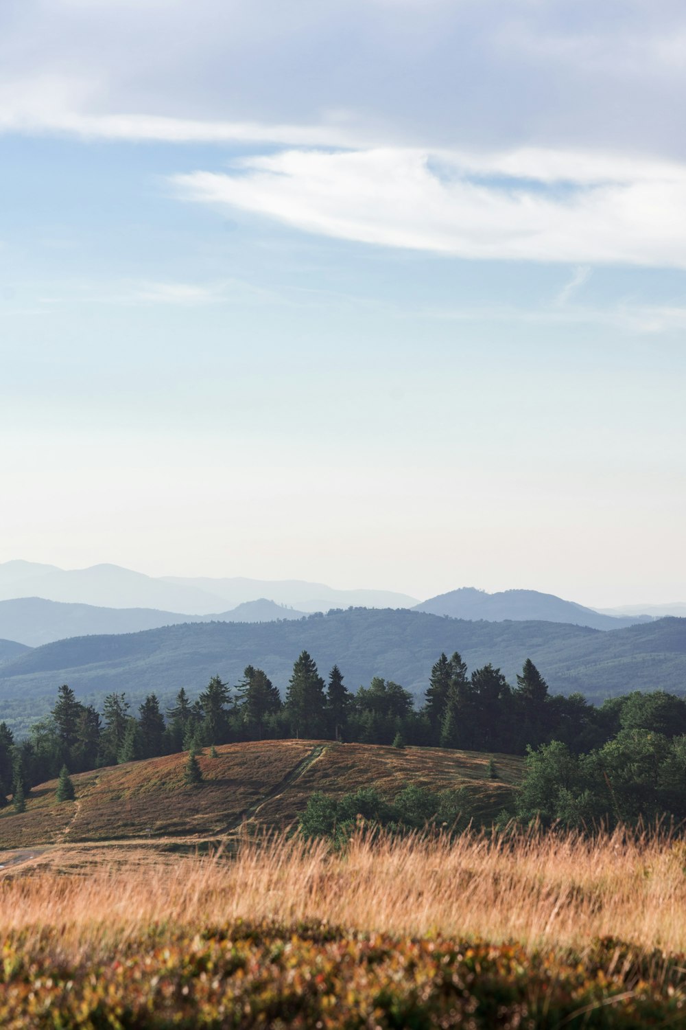 aerial photography of brown field viewing mountain under white and blue sky during daytime