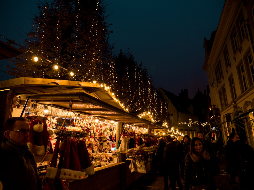 people walking on street with Christmas decor store, Christmas markets in Bruges