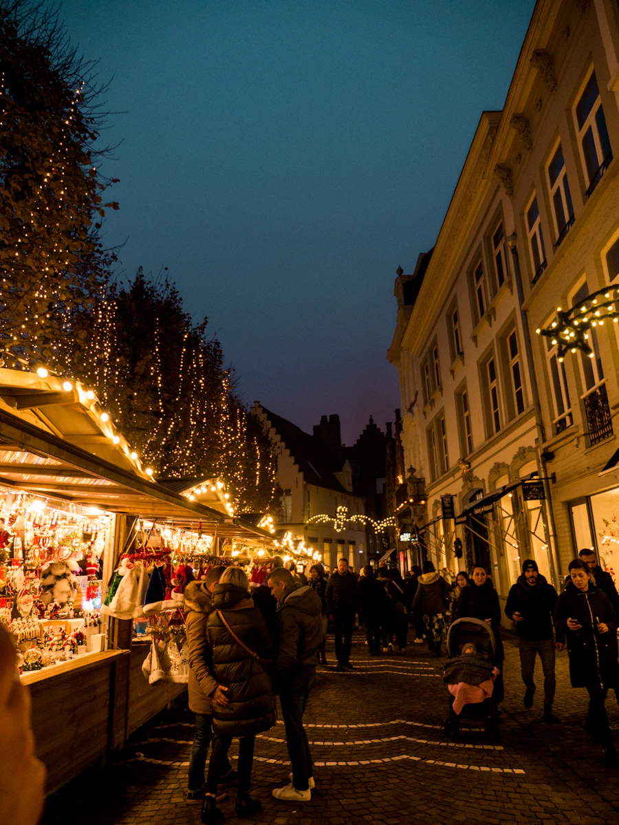 A warmly lit Christmas market at blue-hour dusk, string lights over stalls (illustrative)