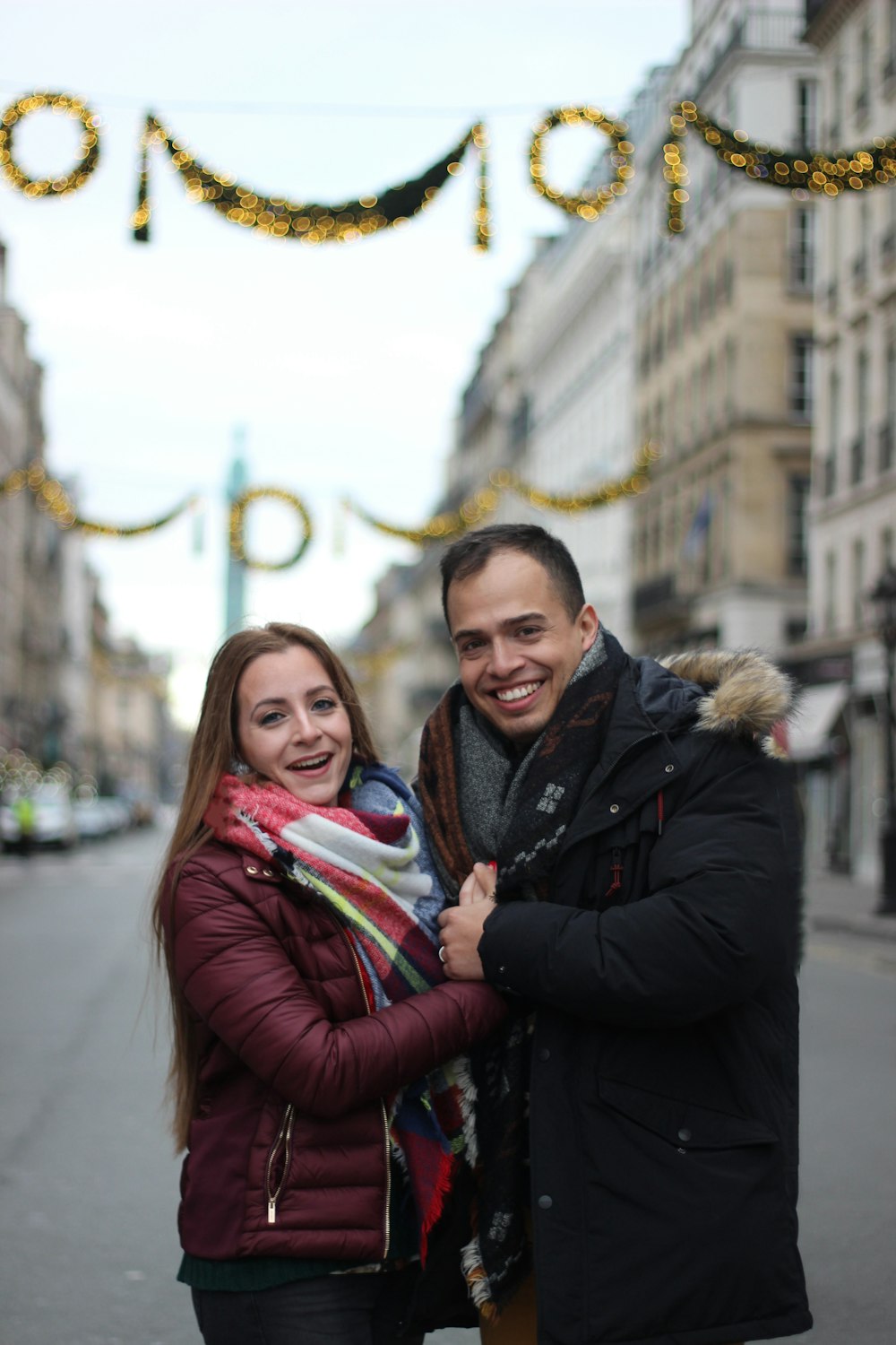 smiling man and woman by buildings during daytime