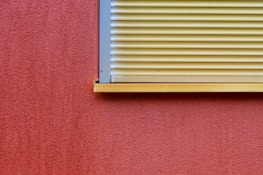 Close-up of a rustic red textured wall with modern minimalist decorations.