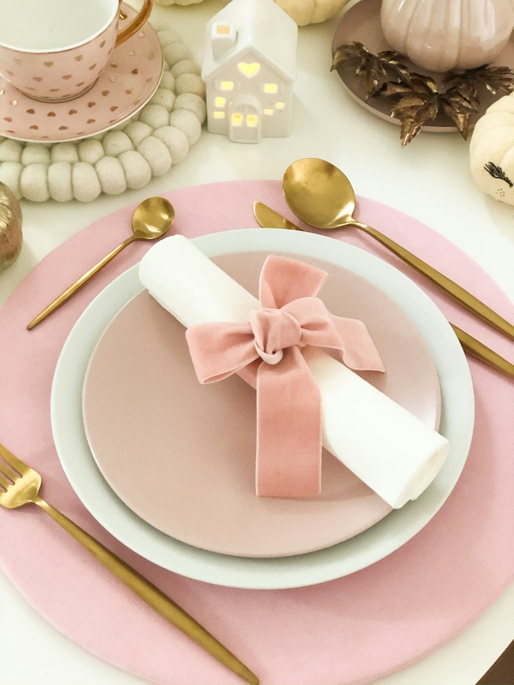 table napkin with bow on plate with charger along with spoons and fork