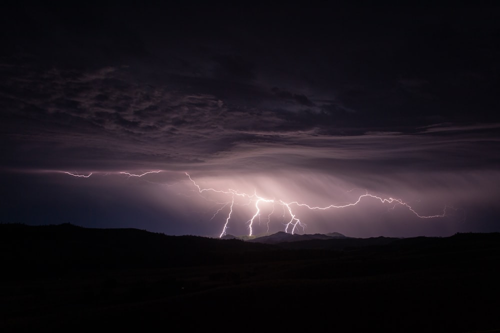 silhouette photography of mountain and lightning bolt