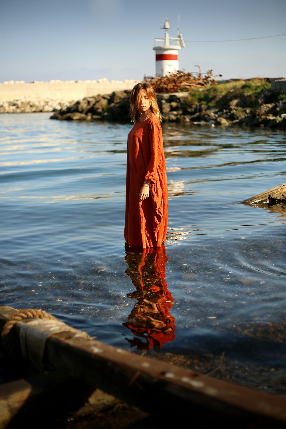 woman in red dress on body of water