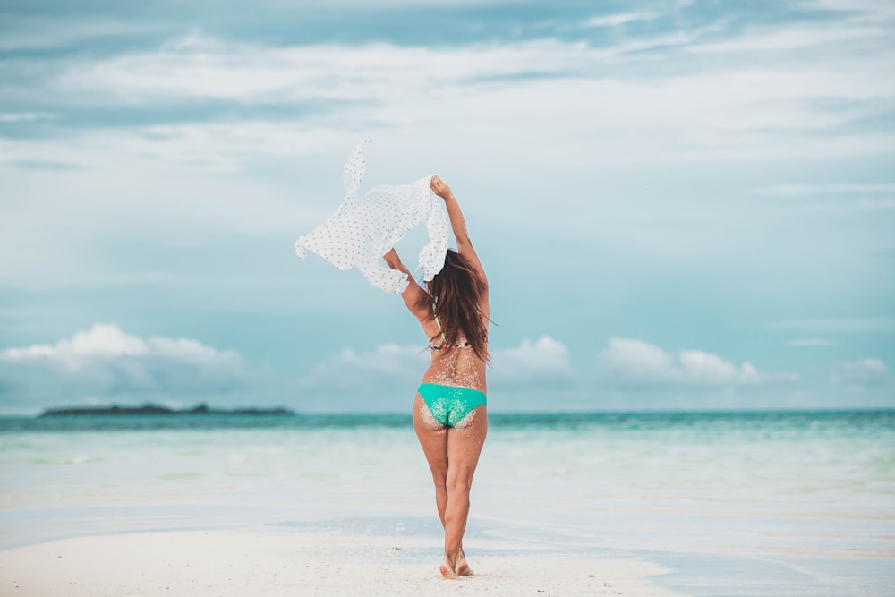 woman in green bikini standing on shore