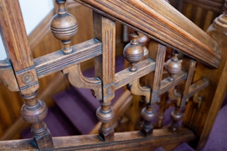 A skilled carpenter carefully fitting a wooden stair railing in a cozy southern Oregon home.