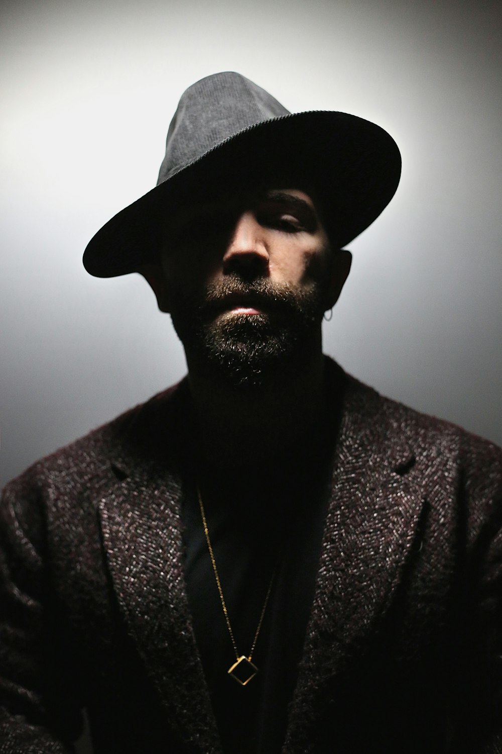 man wearing gray notched lapel blazer and black hat