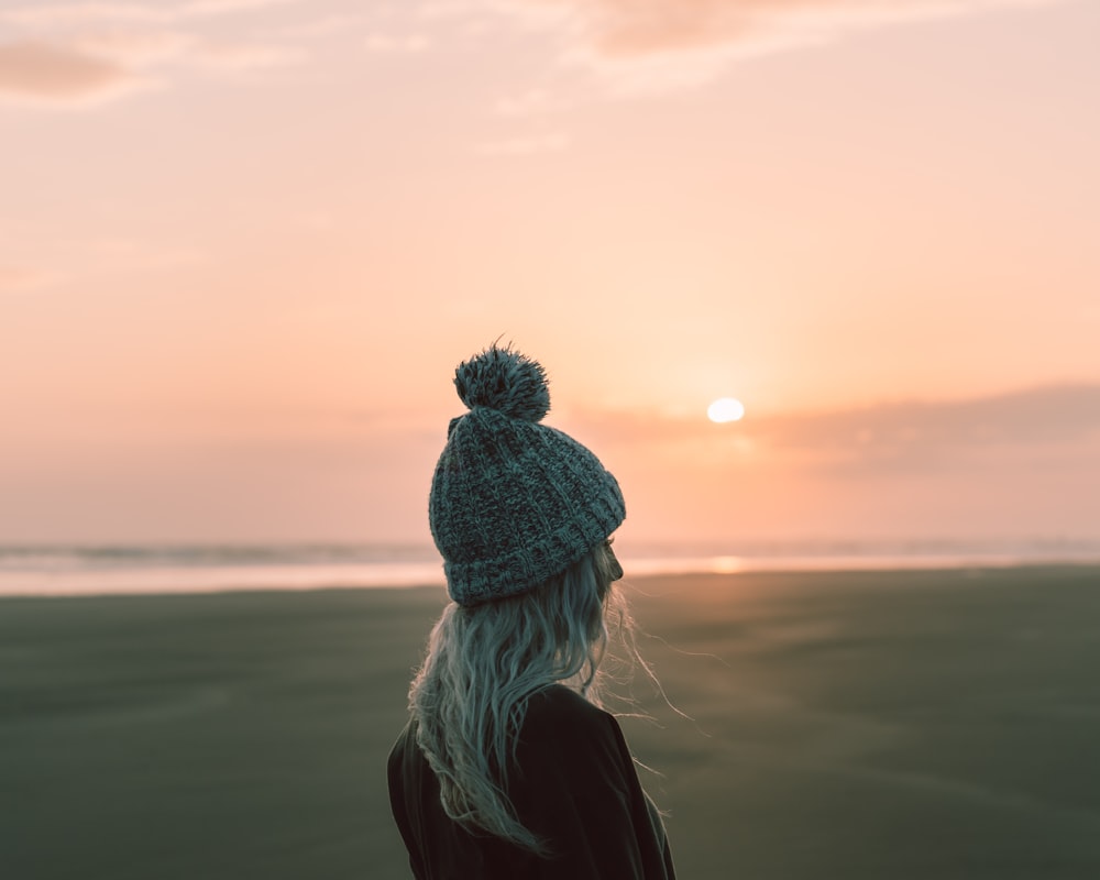 woman wearing black jacket and gray sweater standing