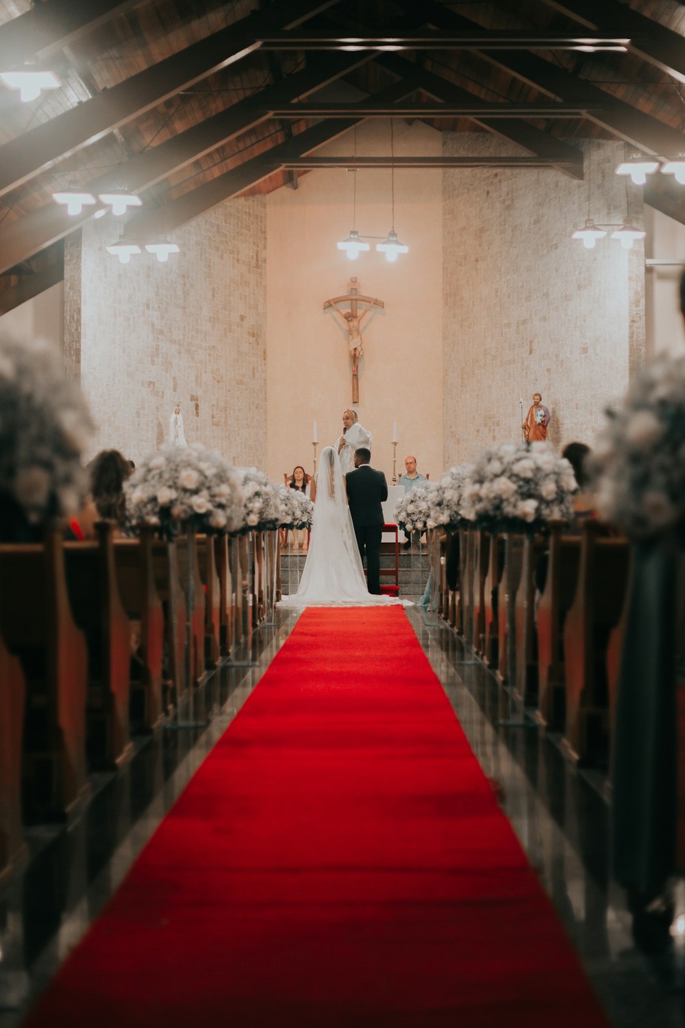 Pareja de recién casados de pie frente al sacerdote