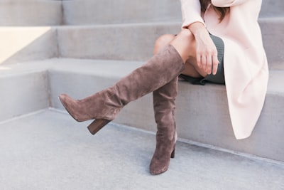 woman wearing pair of brown leather boots boots teams background