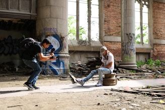 man wearing brown fitted cap sitting near the man holding DSLR camera