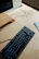 Close-up of colorful cables and a sleek modem on a wooden desk.