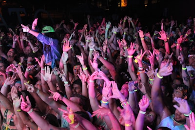 Crowd of enthusiastic young participants cheering under colorful neon lights at the hydro rocket festival.