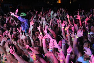 Crowd at a Tampa concert, hands in the air glowing with neon bracelets, vibing to Bigg Britt’s music.