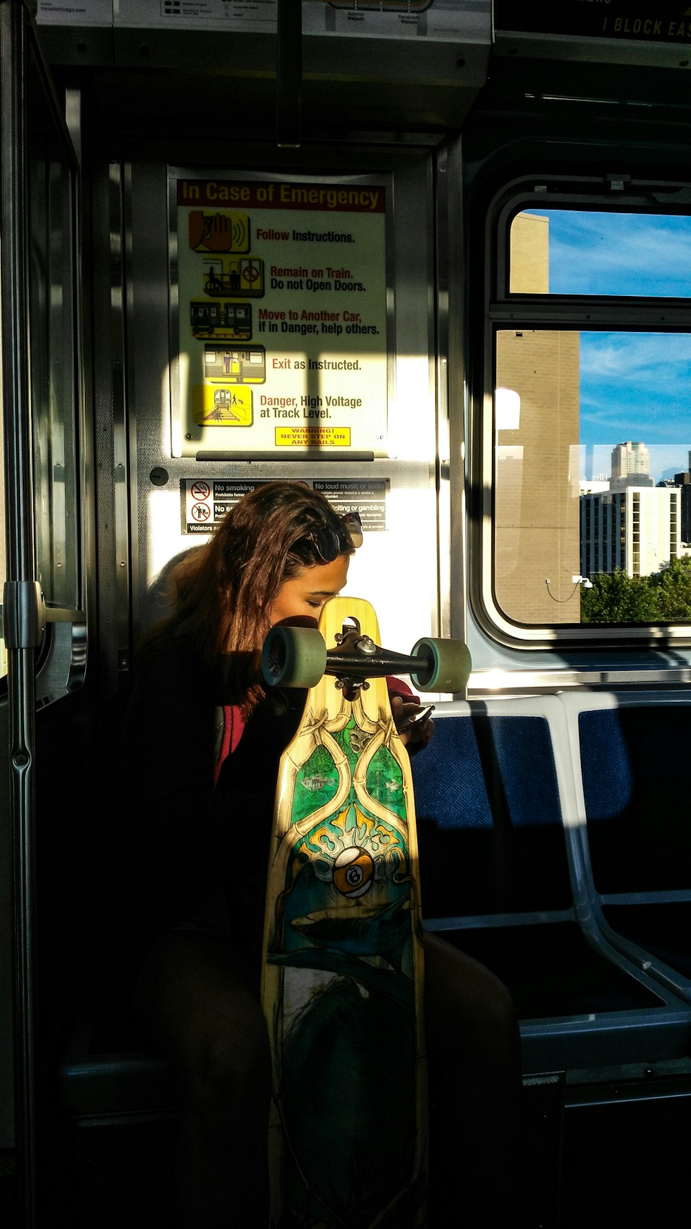 woman sitting on blue chair holding longboard