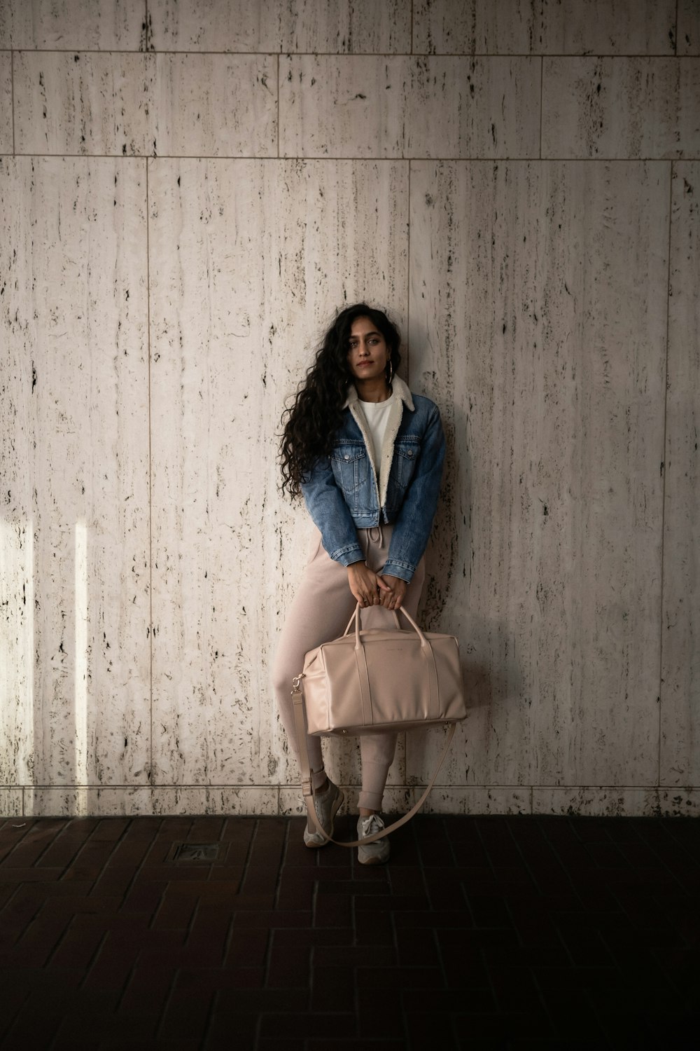 woman wearing blue denim jacket and beige pants