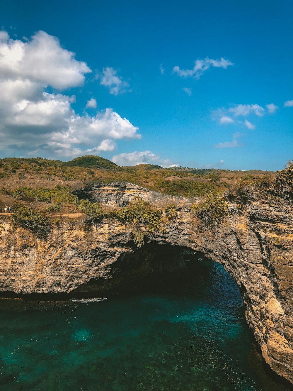 Fotografía de la montaña junto a la orilla del mar durante el día