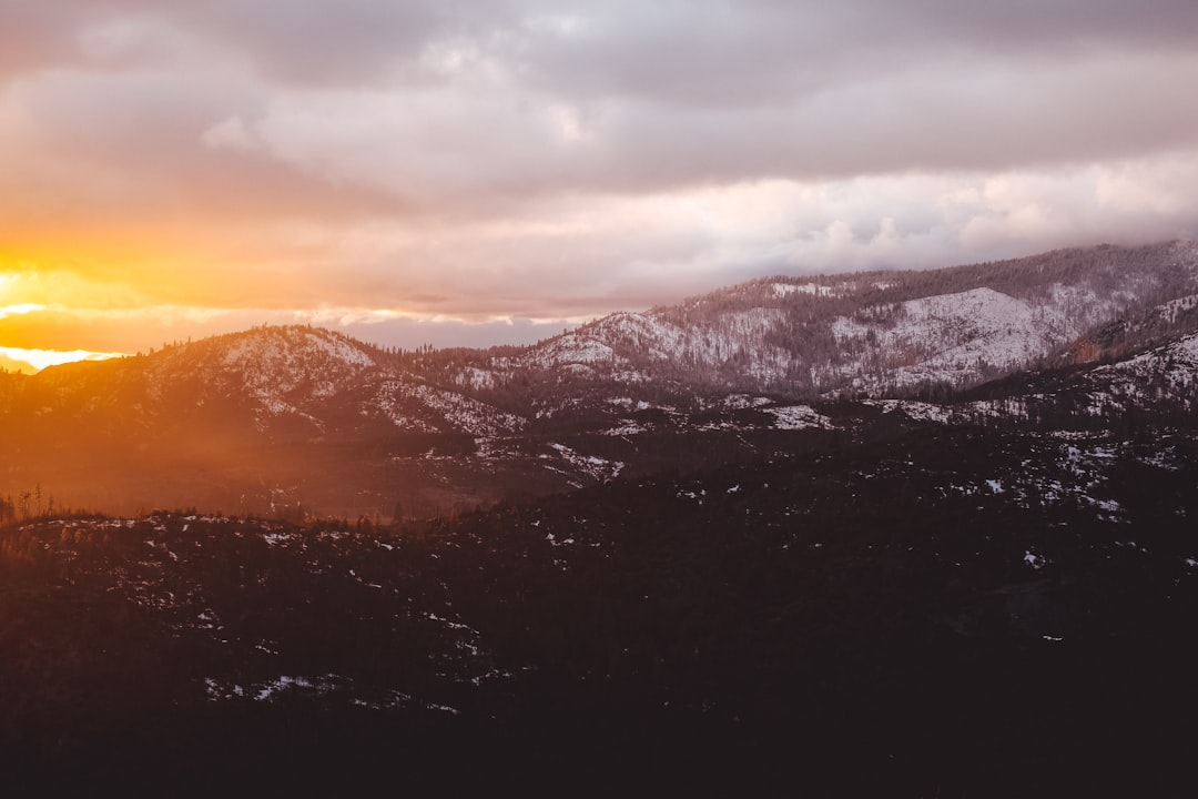 brown and white mountains and clouds