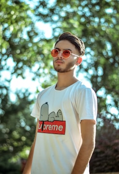 man wearing white and red Supreme crew-neck shirt