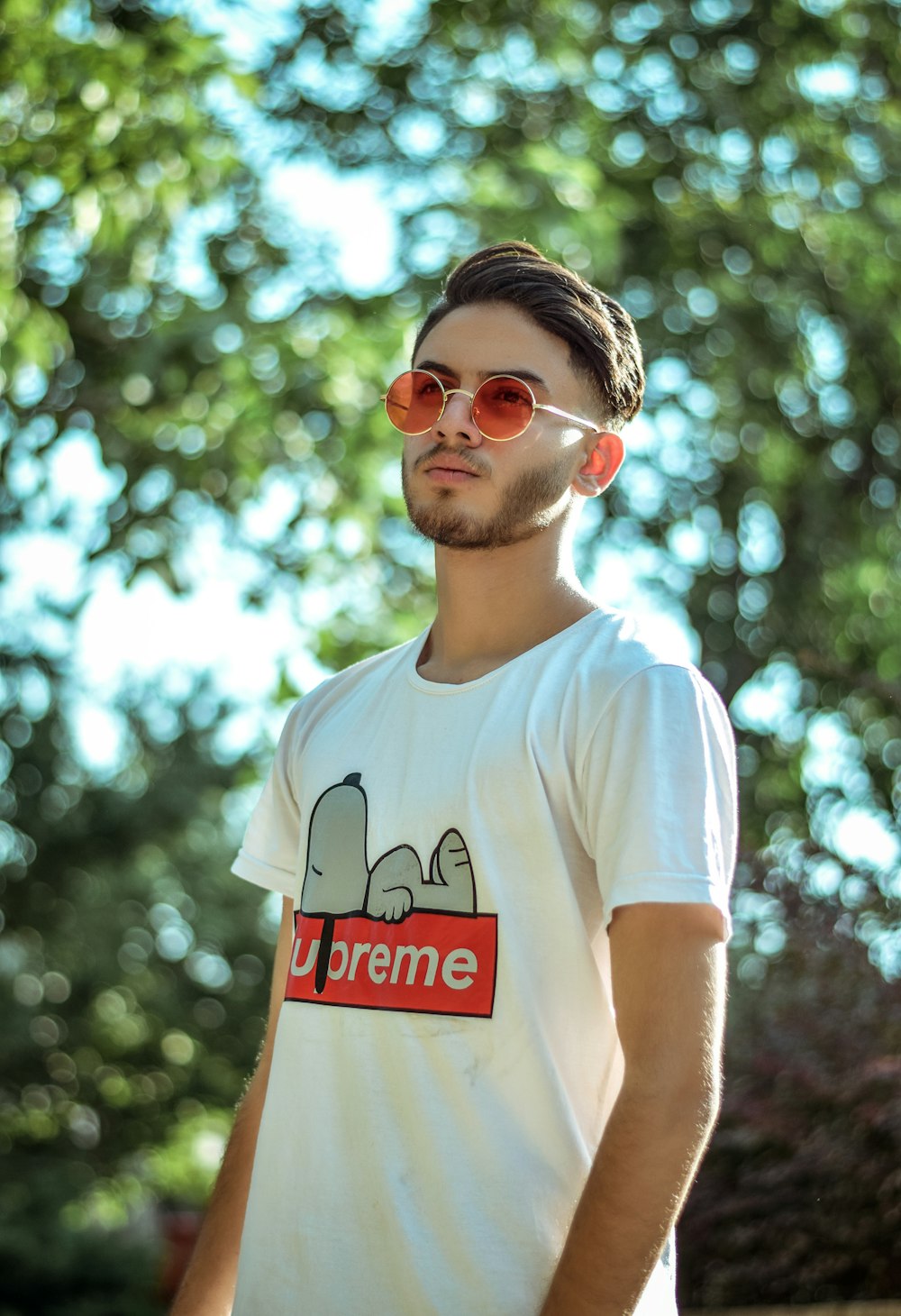 man wearing white and red Supreme crew-neck shirt