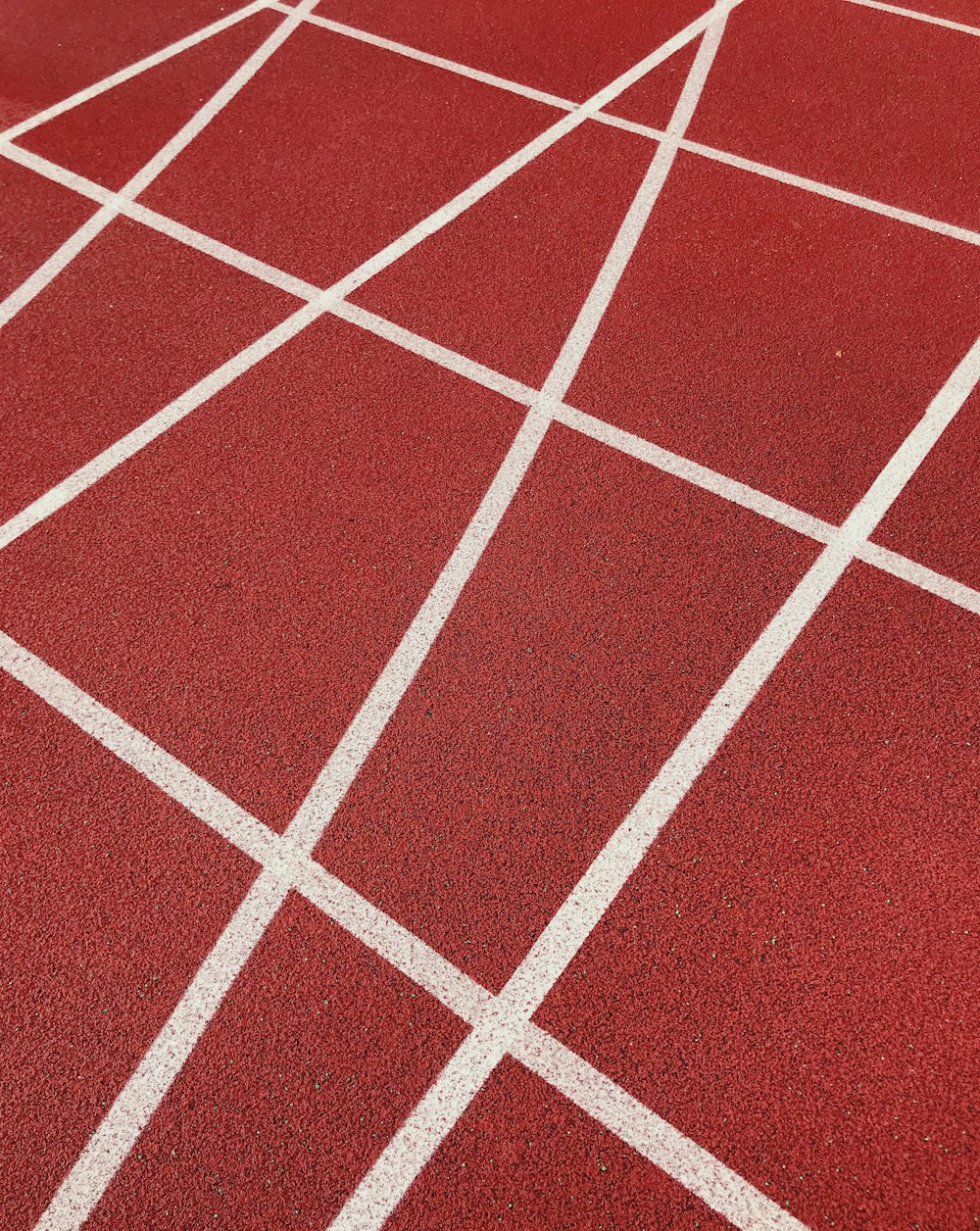 a close up of a red tennis court with white lines