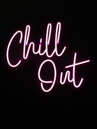 Neon sign with the words 'Chill Out' glowing in bright pink against a dark background.