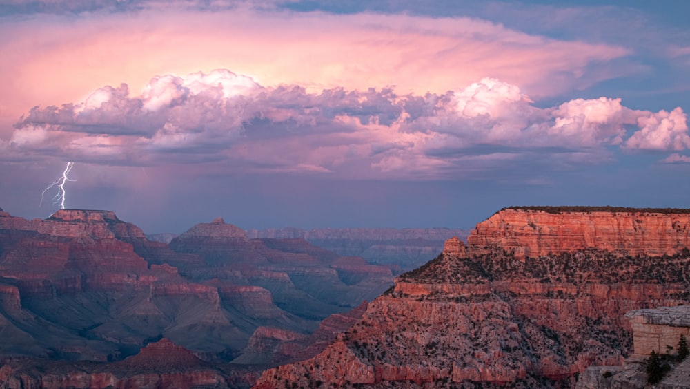 a lightning strikes in the sky over a canyon