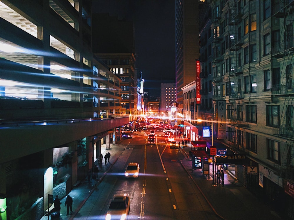 a city street at night with traffic and buildings