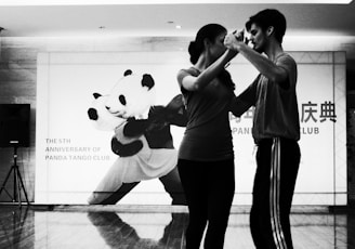 grayscale photo of dancing man and woman inside room