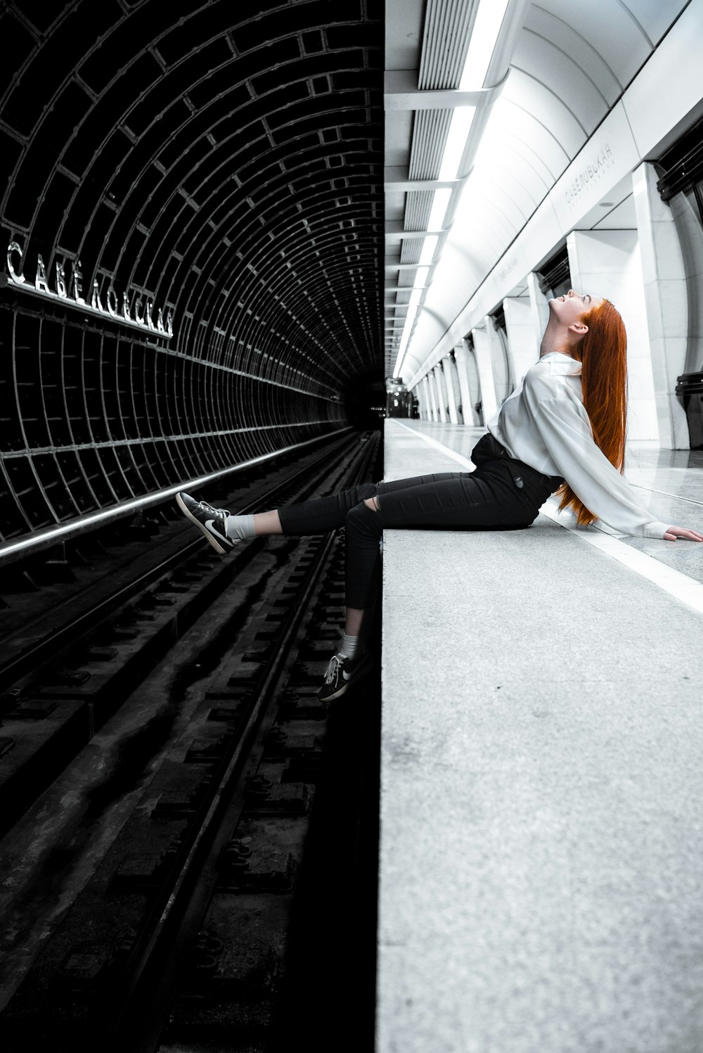 mulher sentada na estação de metrô