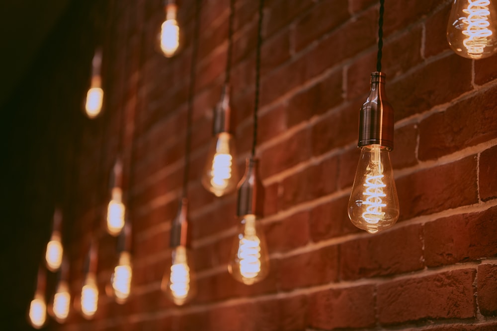 pendant lamps beside brick wall