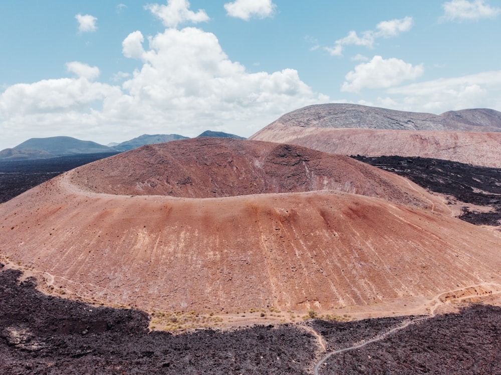 aerial photo of brown mountains under cloudy sky