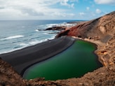 photography of lake beside mountain and seashore during daytime
