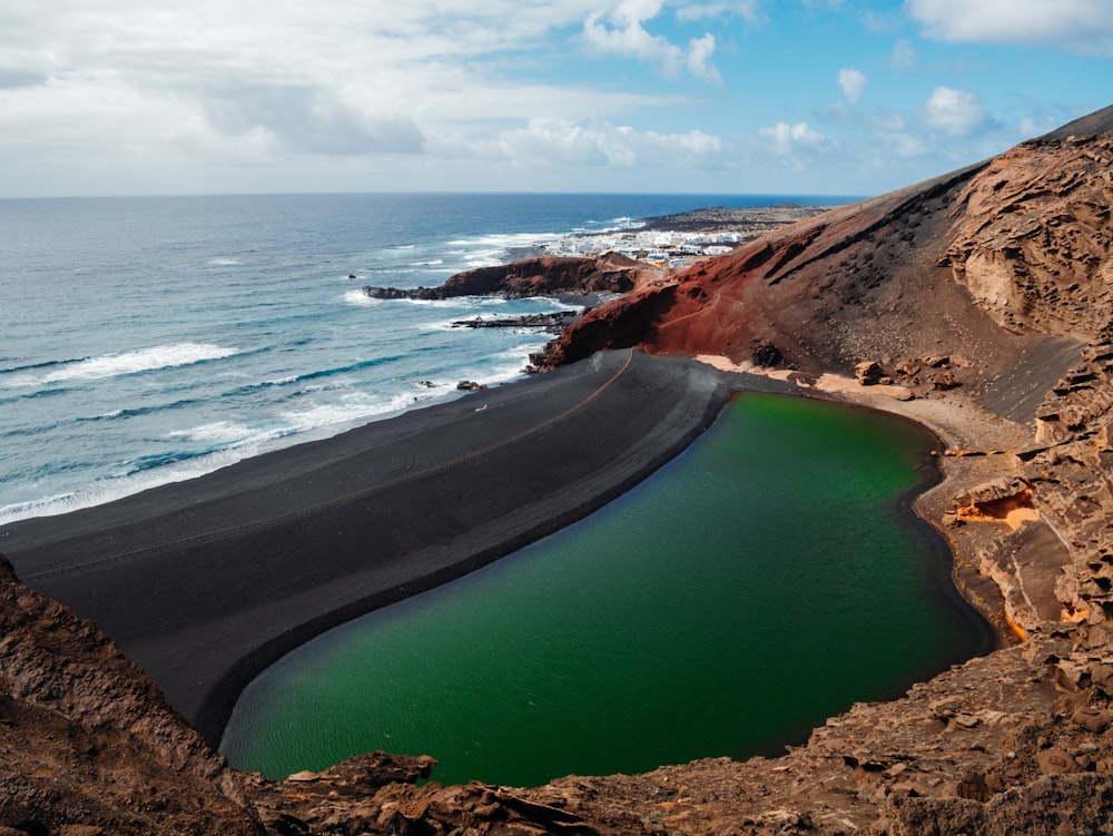 photography of lake beside mountain and seashore during daytime