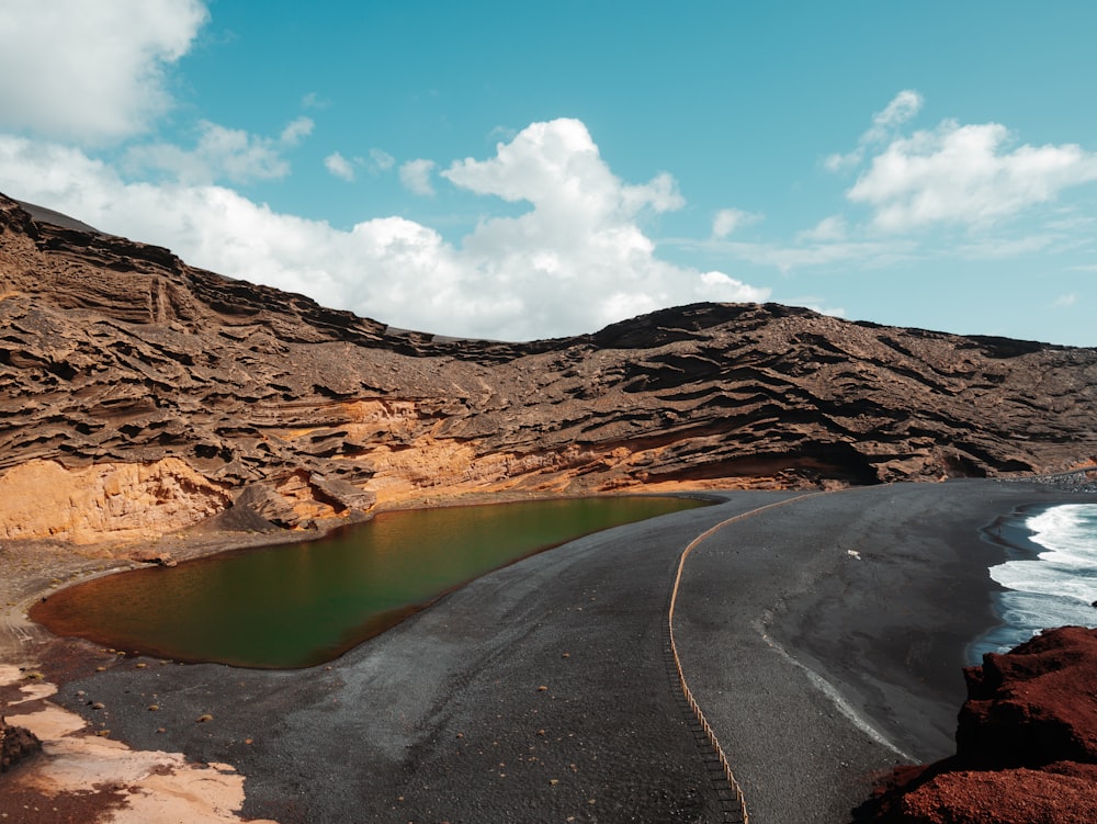 body of water and brown hill