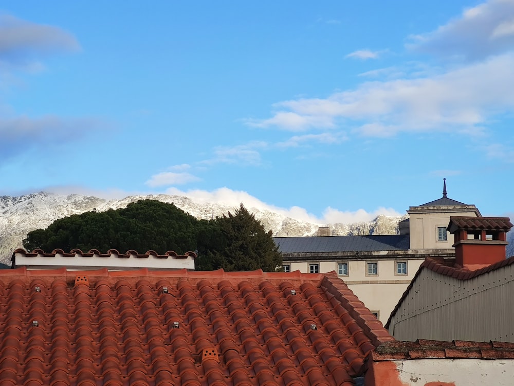 a red tiled roof with mountains in the background