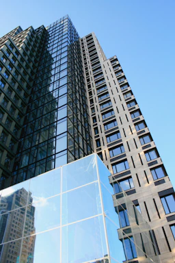High-rise building with glass facade reflecting the blue sky.