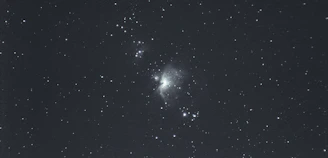 A vibrant photo of a community gathering under a starry blue nebula sky.