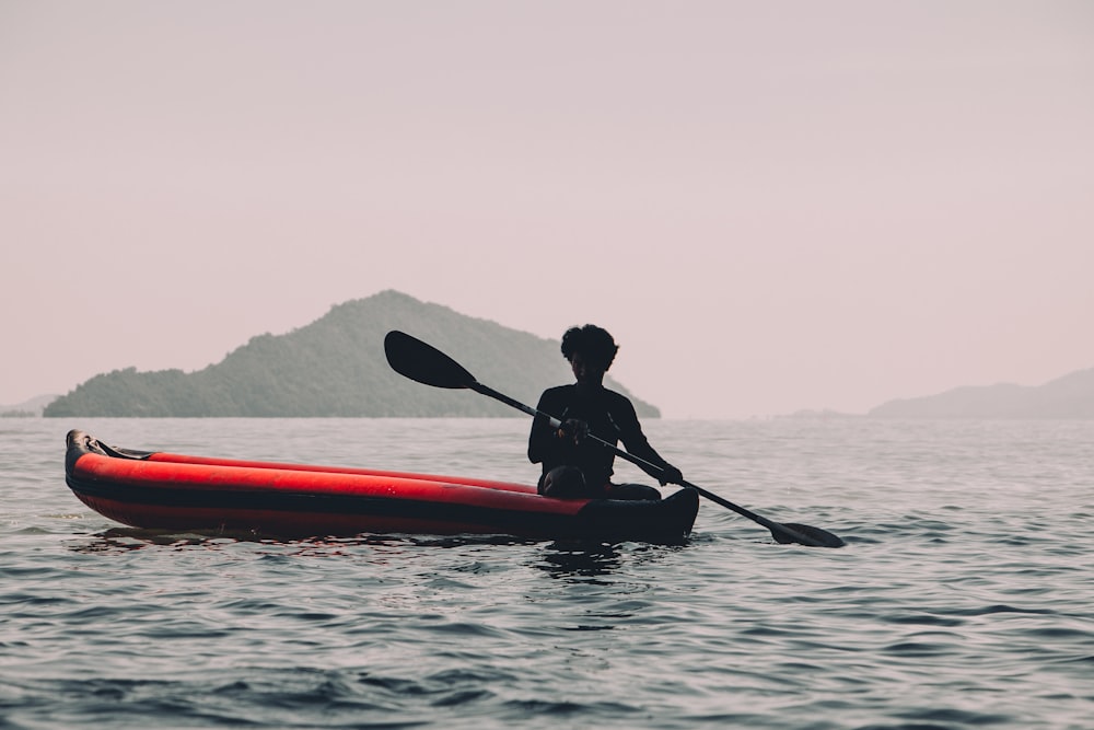 person riding red kayak