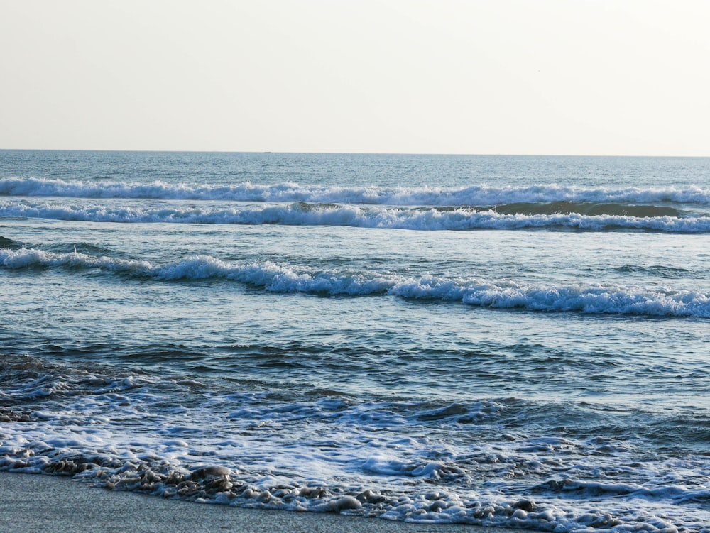 a person riding a surfboard on top of a wave covered beach