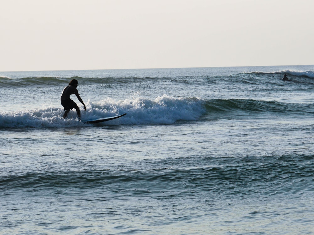 a man riding a wave on top of a surfboard