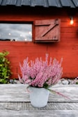 Violet flowers arranged in charming small pots on a wooden table.