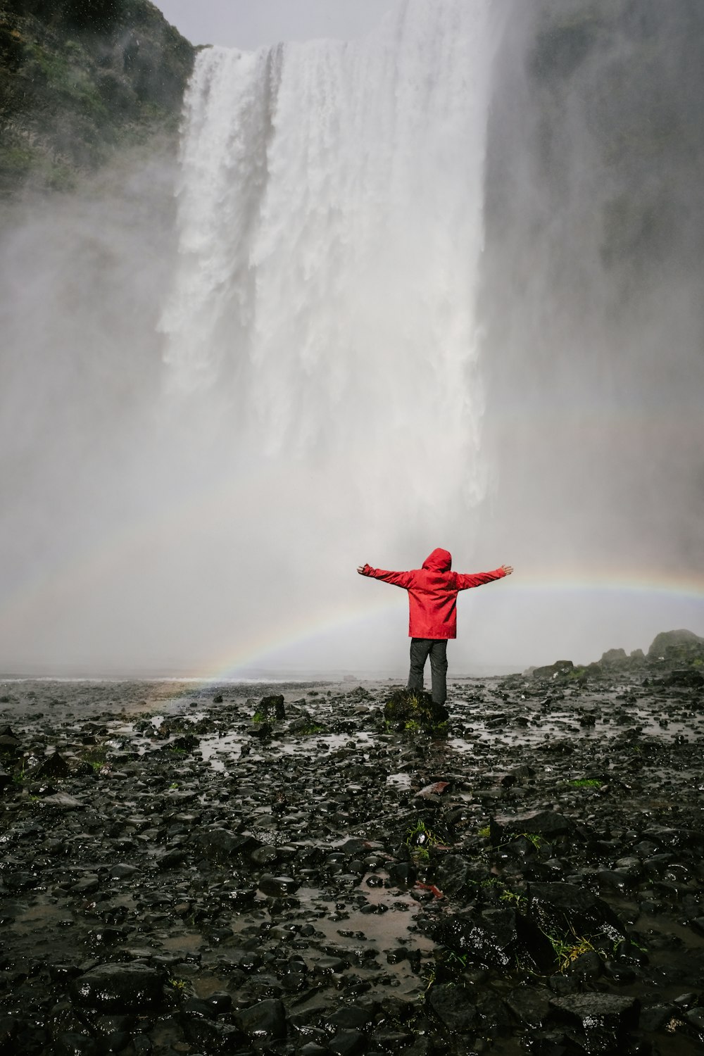 person standing infront of waterfalls