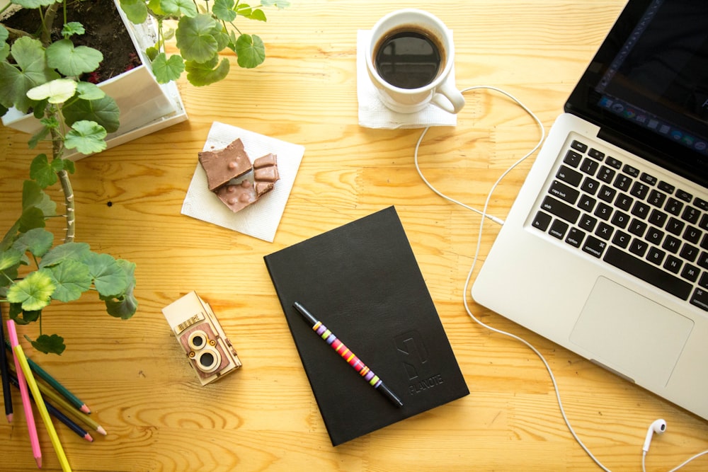 MacBook Pro beside cup of coffee