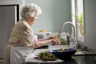 A friendly home health aide supporting a senior with daily activities in their kitchen.