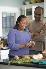 The chef and co-owner smiling together in the kitchen, surrounded by fresh local produce.