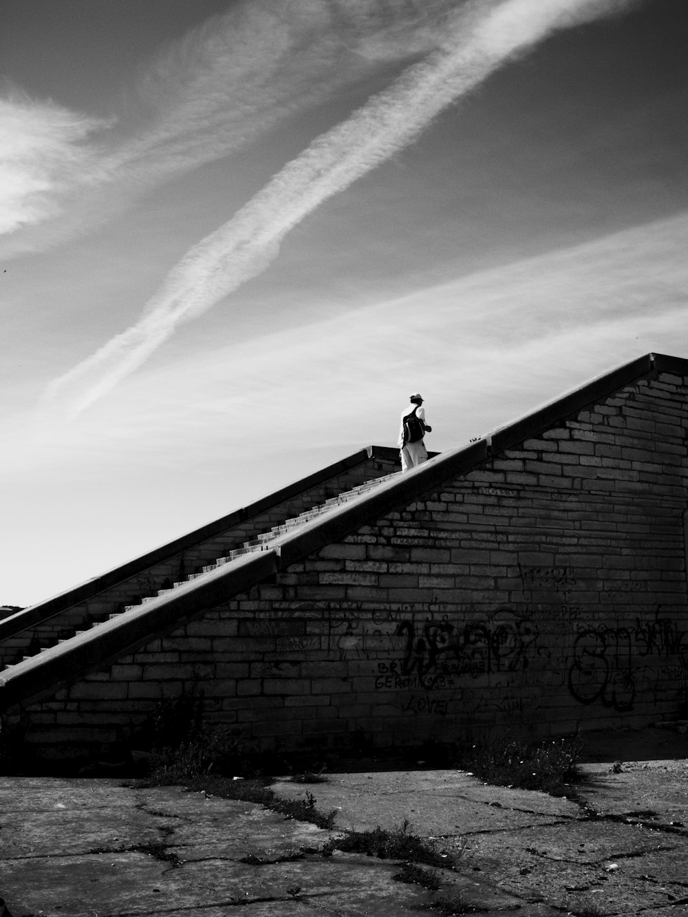 grayscale photography of person walking on staurs going up