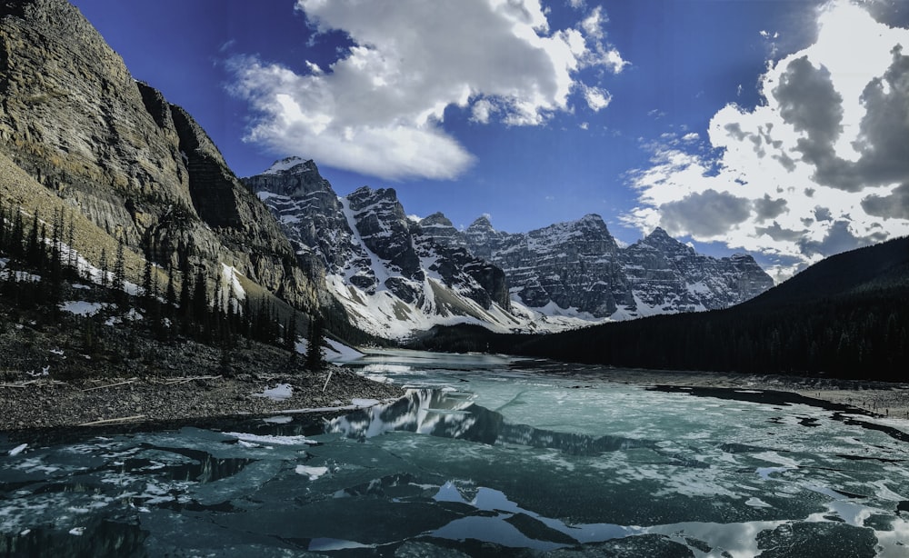 a mountain lake surrounded by snow covered mountains