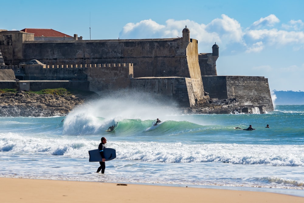 people surfboarding on beach near fort