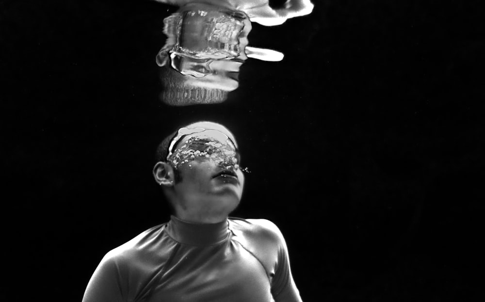 a woman in a tank top and a man in a mask under water